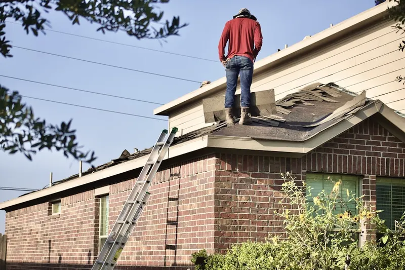 Professional roofer working on a residential roof in Sims